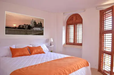 a bedroom with a bed with orange pillows at Hotel Boutique La Artilleria in Cartagena de Indias