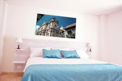 a bedroom with a large bed with a building in the background at Hotel Boutique La Artilleria in Cartagena de Indias