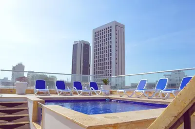 a pool with blue lounge chairs on a roof at Hotel Boutique La Artilleria in Cartagena de Indias