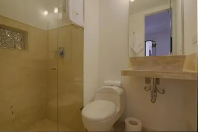 a bathroom with a toilet and a glass shower at Hotel Boutique La Artilleria in Cartagena de Indias