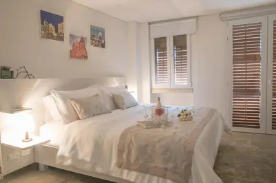a white bedroom with a white bed with flowers on it at Hotel Boutique La Artilleria in Cartagena de Indias