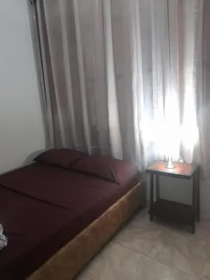 a bedroom with a bed and a table with a lamp at La fantástica Mi Hostal in Cartagena de Indias