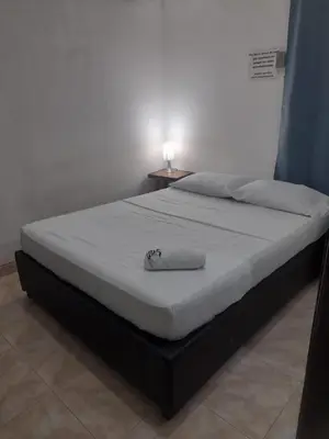 a bed in a bedroom with a white mattress at La fantástica Mi Hostal in Cartagena de Indias
