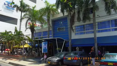 a street with cars parked in front of a building at Mintaka Hotel + Lounge in Cartagena de Indias