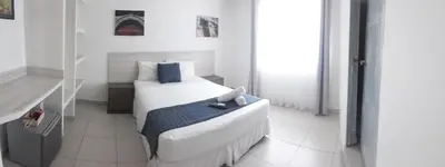 a bedroom with a white bed with blue pillows at Mintaka Hotel + Lounge in Cartagena de Indias