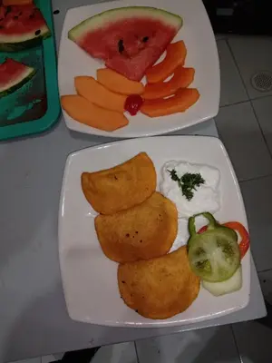 two plates of food with fruit and vegetables on a table at Santa Alejandría Hotel in Cartagena de Indias