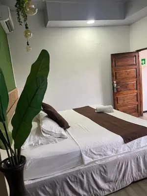 a bedroom with a large bed with a plant at Santa Alejandría Hotel in Cartagena de Indias
