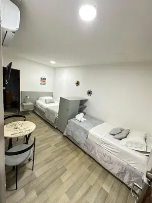 a hotel room with two beds and a table at Santa Alejandría Hotel in Cartagena de Indias