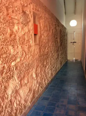 a hallway with a stone wall with a tile floor at Zana Hotel Boutique in Cartagena de Indias