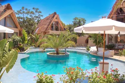 a pool at a resort with an umbrella at VelaNova Paradise - HotelRetreat in Isla Fuerte