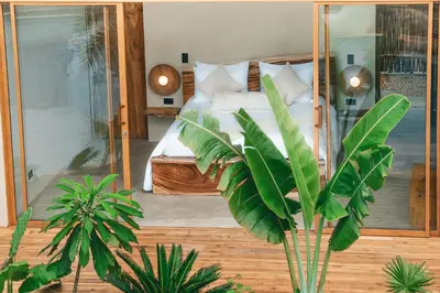 a bedroom with a bed with green plants in it at VelaNova Paradise - HotelRetreat in Isla Fuerte