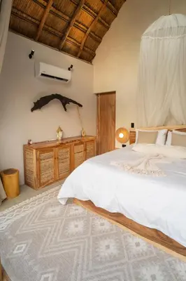 a bedroom with a large bed and a wooden dresser at VelaNova Paradise - HotelRetreat in Isla Fuerte