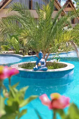 a statue of a man sitting in a pool at VelaNova Paradise - HotelRetreat in Isla Fuerte