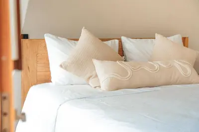 a bed with white sheets and pillows on it at VelaNova Paradise - HotelRetreat in Isla Fuerte