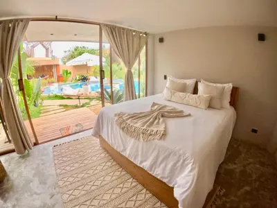 a bedroom with a bed with a view of a pool at VelaNova Paradise - HotelRetreat in Isla Fuerte