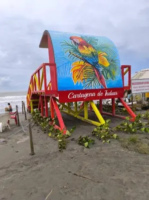 a colorful playground on a beach with the ocean at Acogedor espacio -Serena del Mar in Cartagena de Indias