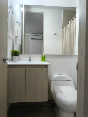 a bathroom with a toilet and a sink and a mirror at Acogedor espacio -Serena del Mar in Cartagena de Indias