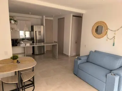 a living room with a blue couch and a kitchen at Acogedor espacio -Serena del Mar in Cartagena de Indias