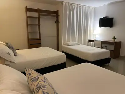 a hotel room with two beds and a television at Hotel Soleira in Tolú