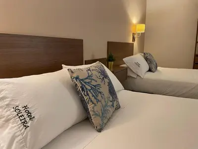a hotel room with two beds and a headboard at Hotel Soleira in Tolú