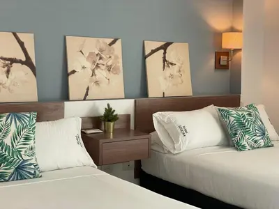 a hotel room with two beds and a table at Hotel Soleira in Tolú
