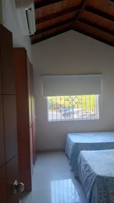 a bedroom with a bed and a window at Habitación Canarios in Barranquilla