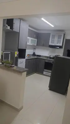 a kitchen with gray cabinets and a black refrigerator at Habitación Canarios in Barranquilla