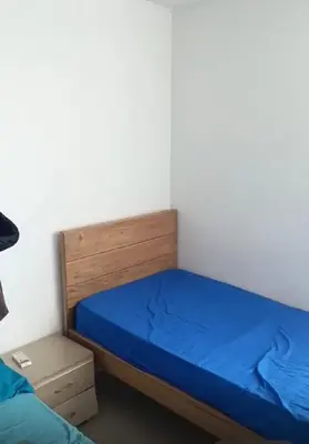 a small bedroom with a bed with blue sheets at Habitación Canarios in Barranquilla