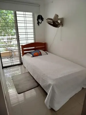 a bedroom with a bed with a fan and a window at Habitación Colibrí in Barranquilla
