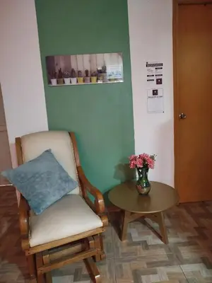 a room with a chair and a table with a vase of flowers at La casita de jo in Cartagena de Indias