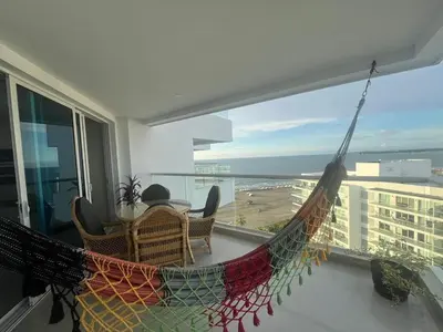 a hammock on a balcony with a view of the ocean at Lux Oceanfront Apartment in Cartagena de Indias