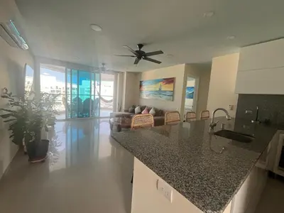 a kitchen and living room with a ceiling fan at Lux Oceanfront Apartment in Cartagena de Indias
