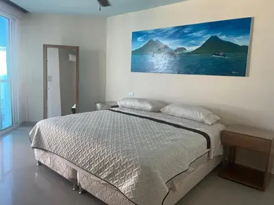 a bedroom with a bed and a painting on the wall at Lux Oceanfront Apartment in Cartagena de Indias