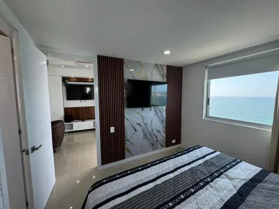 a bedroom with a bed and a large window with the ocean at Apto Luxury cartagena 2401 Palmetto1 Frente al Mar in Cartagena de Indias