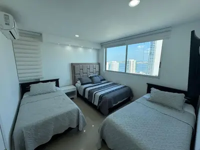 a bedroom with two beds and a window at Apto Luxury cartagena 2401 Palmetto1 Frente al Mar in Cartagena de Indias