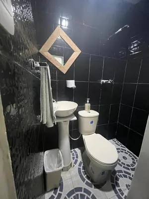 a black tiled bathroom with a toilet and a sink at Hostal la muralla getsemani in Cartagena de Indias