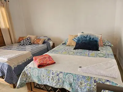 two beds with pillows on them in a room at Cabaña Flor de Loto in San Bernardo del Viento
