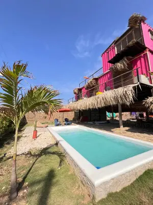 a resort with a swimming pool in front of a building at Surf Mojarra Beach Habitación privada con vista al mar in Salina de Rey