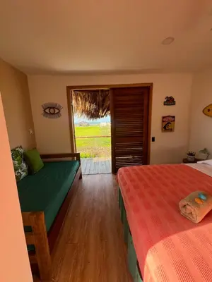 a bedroom with two beds and a sliding glass door at Surf Mojarra Beach Habitación privada con vista al mar in Salina de Rey