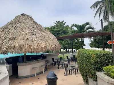 a patio with tables and chairs next to a pool at Apartamento Frente al Mar in Santa Marta