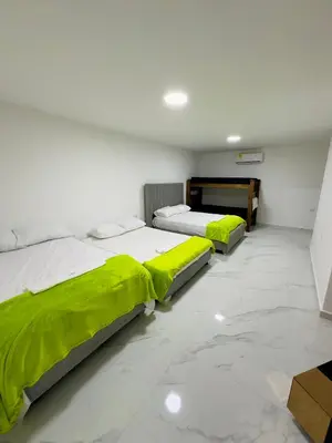 two beds in a room with green sheets at cabaña villa rags in Sabanagrande