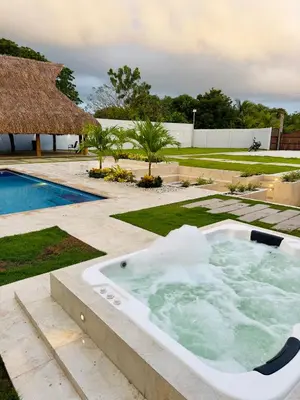 a jacuzzi tub in a garden next to a pool at cabaña villa rags in Sabanagrande