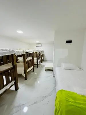 a room with a row of beds and tables at cabaña villa rags in Sabanagrande