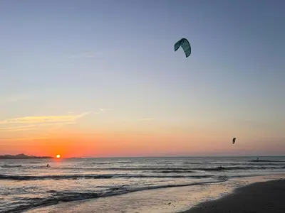 two people flying kites on the beach at sunset at KITE en Mojarra Beach Habitación privada vista al mar in Salina de Rey
