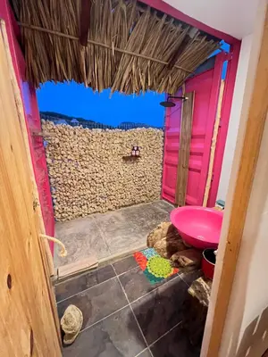 a bathroom with a pink toilet and a wall at KITE en Mojarra Beach Habitación privada vista al mar in Salina de Rey