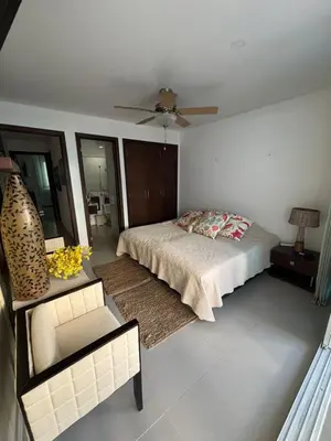 a bedroom with a bed and a chair and a ceiling fan at Beachfront Luxury Apartment Cartagena in Cartagena de Indias