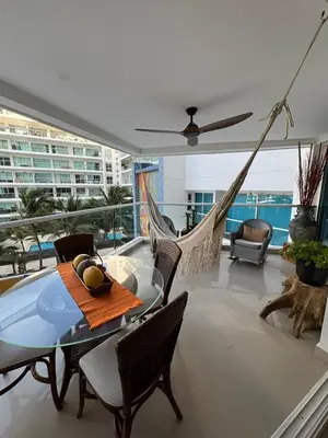 a balcony with a hammock and a table and chairs at Beachfront Luxury Apartment Cartagena in Cartagena de Indias