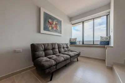 a leather couch in a living room with a window at Unbeatable Location -Exclusive Views- Clock Tower in Cartagena de Indias