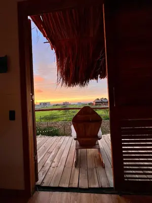 an open door to a porch with a chair on a deck at Love en Mojarra Beach Habitación privada vista al mar in Salina de Rey