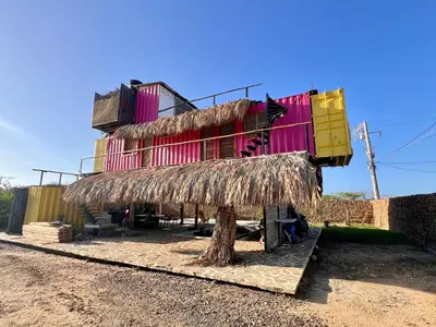 a building with a straw roof on the side of it at Love en Mojarra Beach Habitación privada vista al mar in Salina de Rey